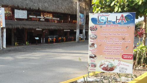 a sign on the side of a street with a building at Hotel LOL-HA in Cobá
