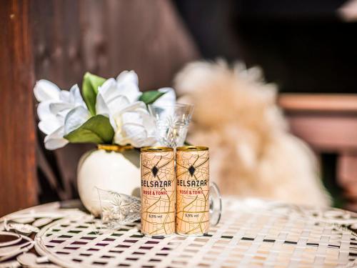 a table with two canisters on a table with a vase at Homely Stay in a romantic lodging with sauna&gym in Münsing am Starnberger See