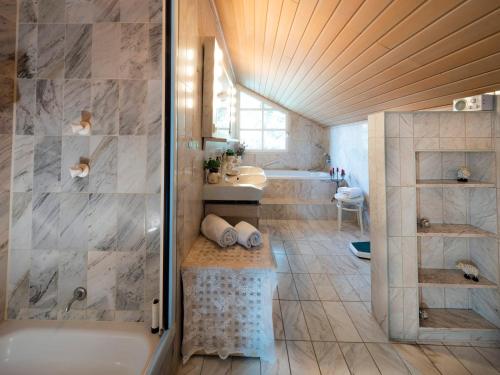 y baño con bañera, lavamanos y ducha. en Homely Stay in a romantic lodging with sauna&gym, en Münsing