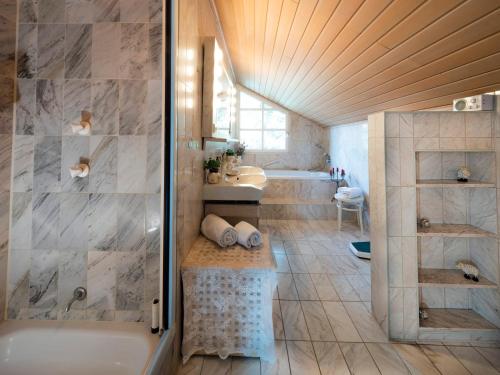 a bathroom with a tub and a sink and a shower at Homely Stay in a romantic lodging with sauna&gym in Münsing am Starnberger See