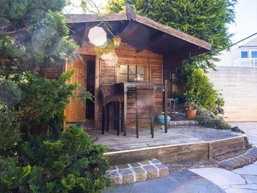 a wooden cabin with a deck with a stove at Homely Stay in a romantic lodging with sauna&gym in Münsing am Starnberger See