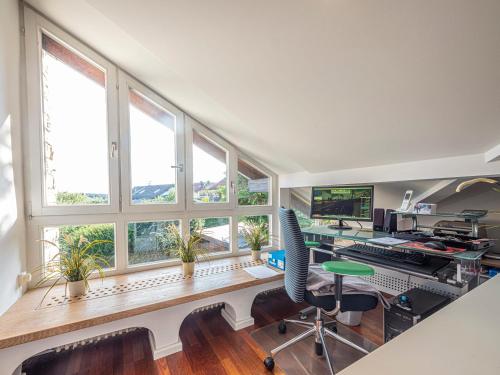 an office with windows and a desk with a computer at Homely Stay in a romantic lodging with sauna&gym in Münsing am Starnberger See