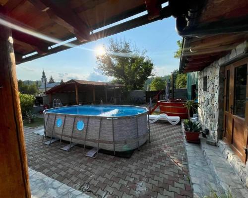 bañera de hidromasaje en un patio con un edificio en Pensiunea Casa Amy en Gladna Romînă