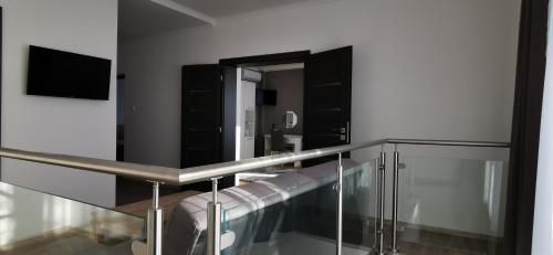 Cette chambre comprend une balustrade en verre et un miroir. dans l'établissement Apartmány Pavlík, à Nesvady