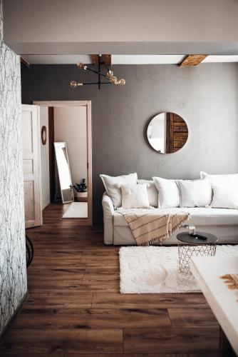 a living room with a white couch and a mirror at Stylish and cozy old town apartment in Võru