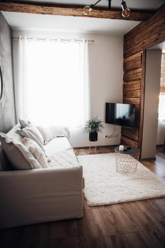 a living room with a white couch and a television at Stylish and cozy old town apartment in Võru