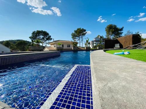a swimming pool with blue tiles in a house at Contempory exclusive Sitges area in Barcelona