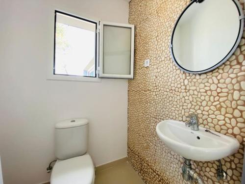 ein Badezimmer mit einem WC, einem Waschbecken und einem Spiegel in der Unterkunft Contempory exclusive Sitges area in Barcelona