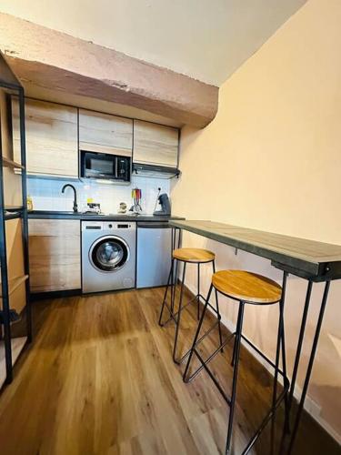 - une cuisine avec un comptoir et deux tabourets dans l'établissement Le Refuge, à Laon