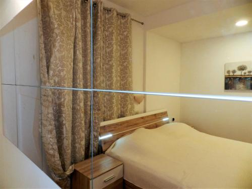 a small bedroom with a bed and a curtain at Apartments Lea in Orebić