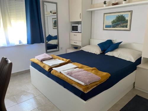 a bedroom with a bed with towels on it at Guesthouse Šimag in Rab