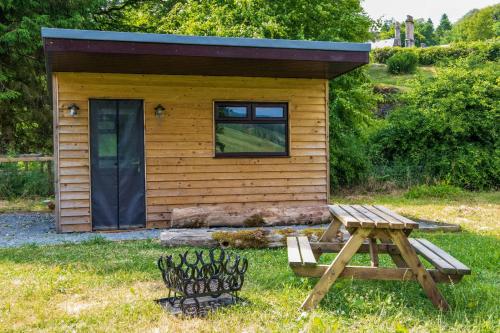 eine kleine Hütte mit einem Picknicktisch davor in der Unterkunft Craigengillan Mini Lodge in Dalmellington