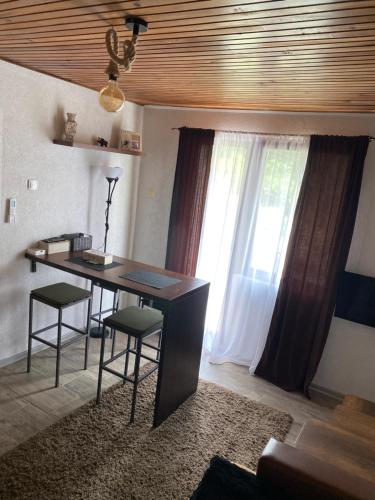 een kamer met een bureau, stoelen en een raam bij Vikendica sa bazenom in Višegrad
