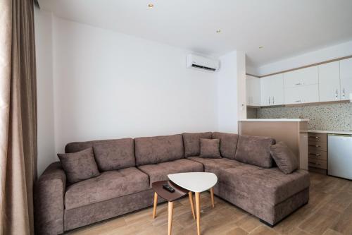 クサミルにあるAjlina Apartmentsのソファとテーブルのあるリビングルーム