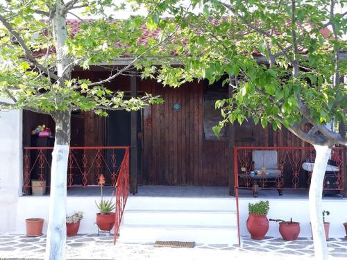 a house with a red gate and some trees at Μονοκατοικία Kathrin in Nea Kalikratia