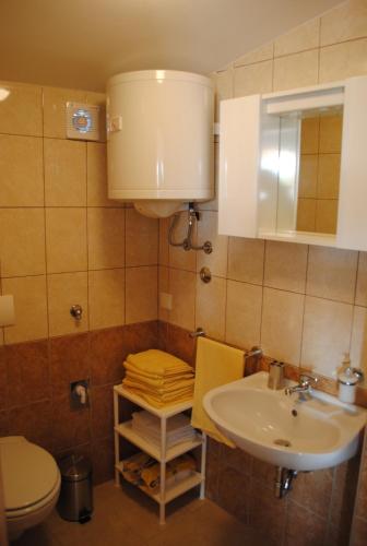 a bathroom with a sink and a toilet at Apartments Kairos - Bili 9 in Kaštela