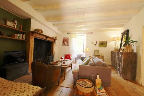 una sala de estar con un sofá y una mesa en La Maisonnette de La Jolie Vie, en Urval