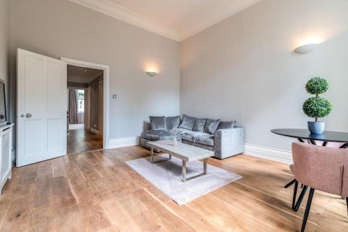 Canal Crescent Charm Flat with Stunning Views Little Venice في لندن: غرفة معيشة مع أريكة وطاولة