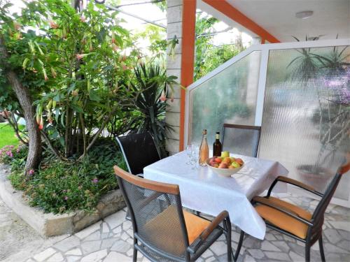 a white table with a bowl of fruit on a patio at Apartments Lea in Orebić