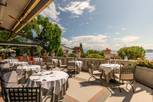 a restaurant with tables and chairs on a patio at Hotel Laurin in Salò