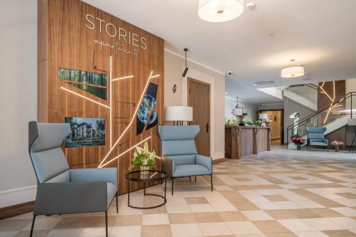 eine Lobby mit Stühlen und eine Wand mit einem Schild darauf in der Unterkunft STORIES Design ApartHotel in Jūrmala