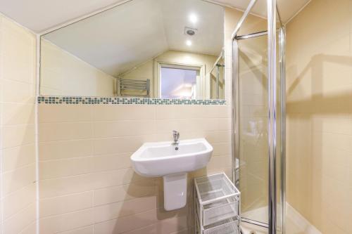 a bathroom with a sink and a shower at Quiet Double Studio Flat in London