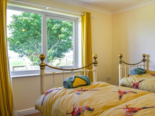 sypialnia z 2 łóżkami i oknem w obiekcie Little Glengyre Farm w mieście Kirkcolm