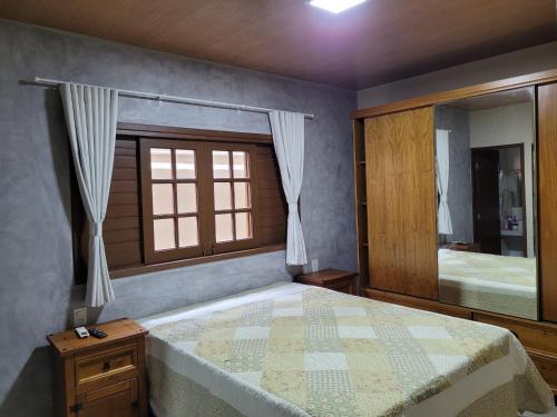 a bedroom with a bed with a window and a mirror at Casa Praia Frances 350m orla Q4 novíssima e superdecorada in Marechal Deodoro