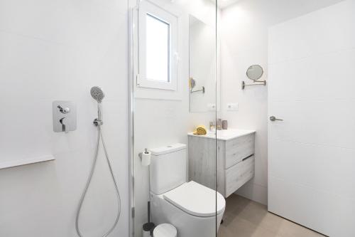 a white bathroom with a toilet and a shower at Casa Piscina Cubierta Climatizada 3 in Chiclana de la Frontera