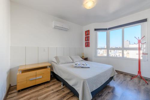 a bedroom with a bed and a dresser and a window at Loft Centro Histórico, Completo e Confortável 502 in Porto Alegre