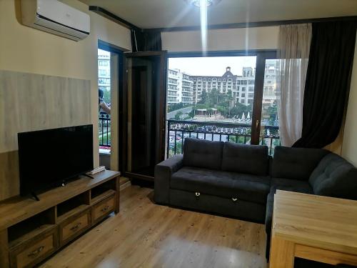 ein Wohnzimmer mit einem Sofa und einem Flachbild-TV in der Unterkunft Апартамент Релакс in Goldstrand
