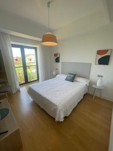 1 dormitorio con cama blanca y ventana grande en LUXURY Casares del Mar DP7, en Casares
