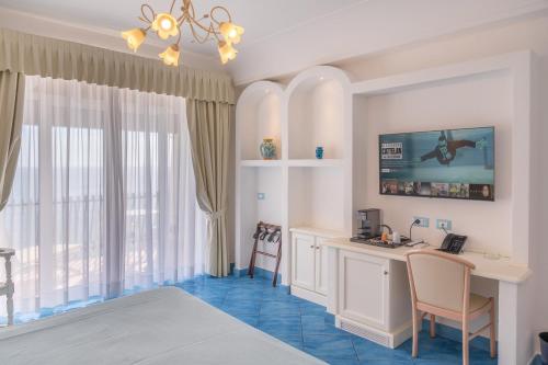 Habitación de hotel con cama, escritorio y mesa. en Grand Hotel Le Rocce, en Gaeta