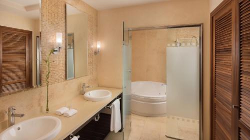een badkamer met 2 wastafels en een douche bij Sheraton Fuerteventura Golf & Spa Resort in Caleta De Fuste