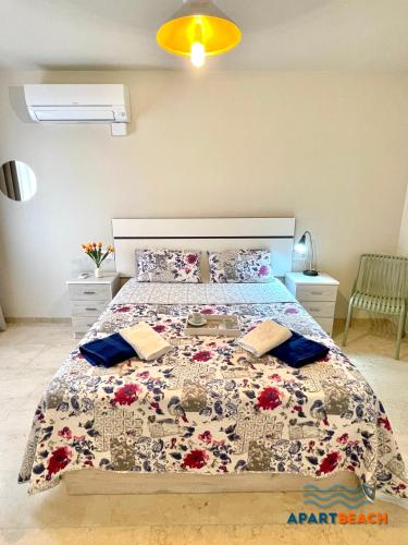 1 dormitorio con 1 cama grande con colcha de flores en APARTBEACH SANCHO ABARCA CENTRICO y JUNTO PLAYA en Salou