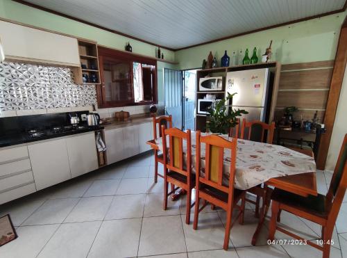 kuchnia ze stołem, krzesłami i lodówką w obiekcie Quarto, piscina, ar condicionado w mieście Encantado