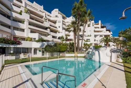 una piscina di fronte a un edificio di Castillo San Carlos Luxury Apartments a Torremolinos