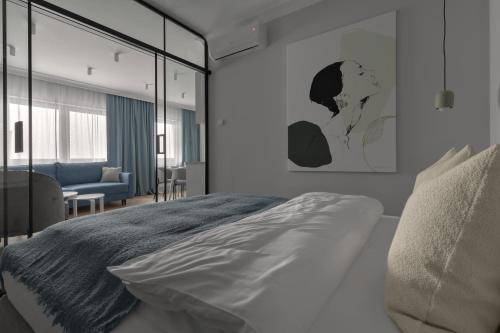a bedroom with a bed and a living room at APARTIO ROOMS Gliwice in Gliwice