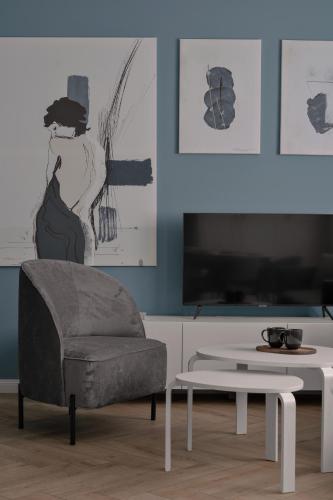 a living room with a chair and a table at APARTIO ROOMS Gliwice in Gliwice