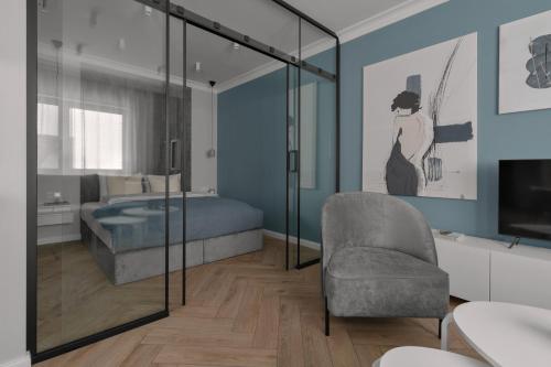 a bedroom with a bed and a chair and a television at APARTIO ROOMS Gliwice in Gliwice