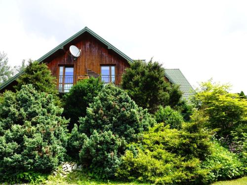 a wooden house with a window on top of trees at Villa Bartek in Tylicz