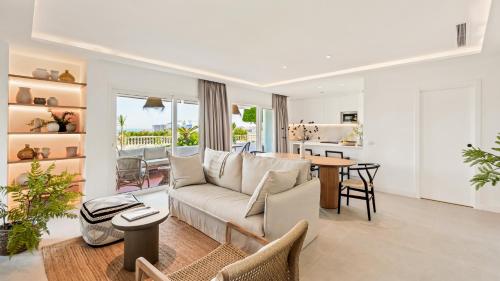 Castillo San Carlos Luxury Apartments في توريمولينوس: غرفة معيشة مع أريكة وطاولة