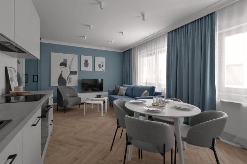 a kitchen and living room with a table and chairs at APARTIO ROOMS Gliwice in Gliwice