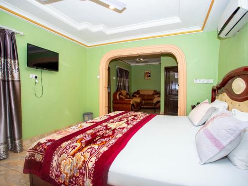 a bedroom with a bed and a living room at Glory Hills Hotel in Kumasi