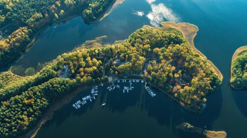 an island in the water with boats on it at Łabędzi Ostrów Ośrodek Wypoczynkowy in Piękna Góra