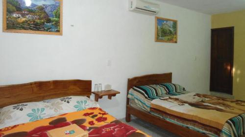 a bedroom with two beds and a table in it at Hotel LOL-HA in Cobá