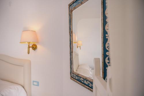 a mirror in a room with a bed and a lamp at Grand Hotel Le Rocce in Gaeta