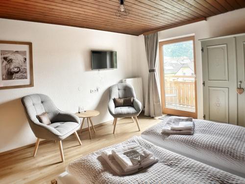 ザンクト・ミヒャエル・イム・ルンガウにあるGasthof Auwirtのベッドルーム1室(ベッド1台、椅子2脚、窓付)