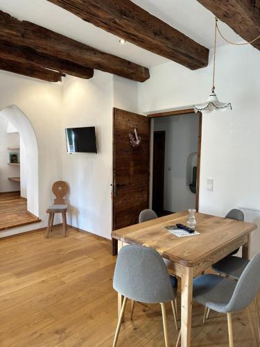 a dining room with a wooden table and chairs at Landhaus Breitenberg in Lana