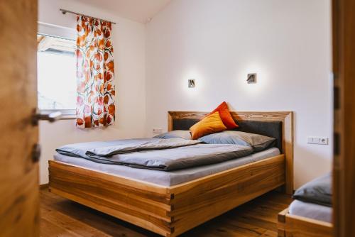 Un dormitorio con una cama de madera en una habitación. en Bewegt Appartements, en Kaprun
